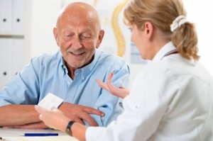 קשיש עם מטפלת שמסבירה לו על התרופות